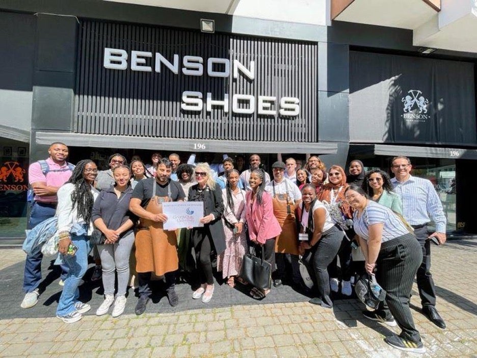 A group of young students posing for a photo together outside a storefront called Benson Shoes.