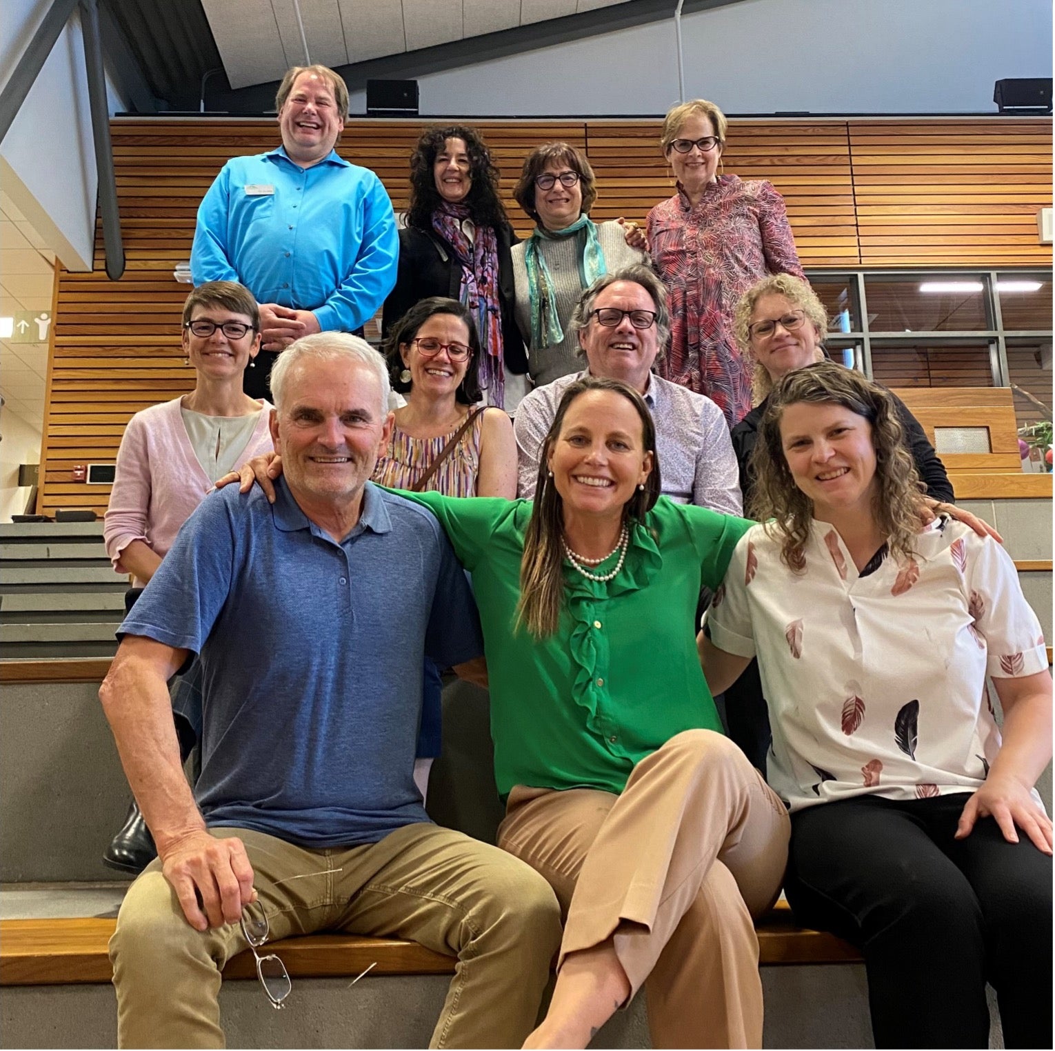 A group of faculty sitting on steps posing for a group photo.